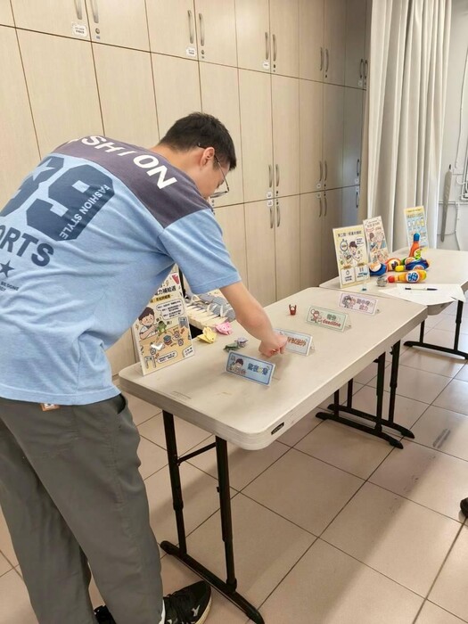 圖說：學生引導戰友青蛙跨越障礙，象徵克服備考路上的種種困難。 (圖/中信科大提供)圖片