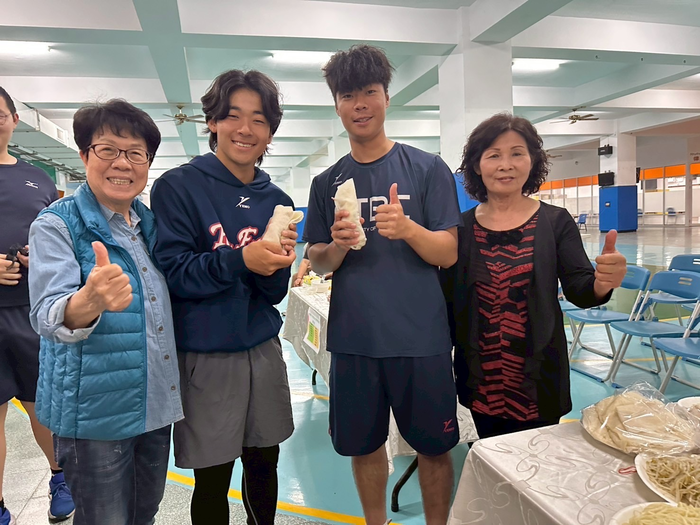 圖說：中信科大棒球隊日本學生山本英之介(左2)與韓國學生崔珉瑞(右2)開心的品嚐春捲大讚好吃(圖/中信科技大學提供)