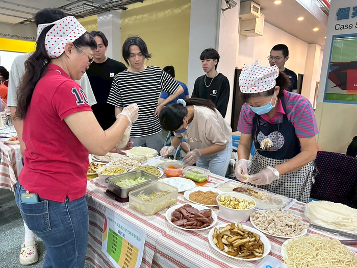 圖說：樂齡大學學員準備豐盛的菜餚和大學生一起包春捲(圖/中信科技大學提供)