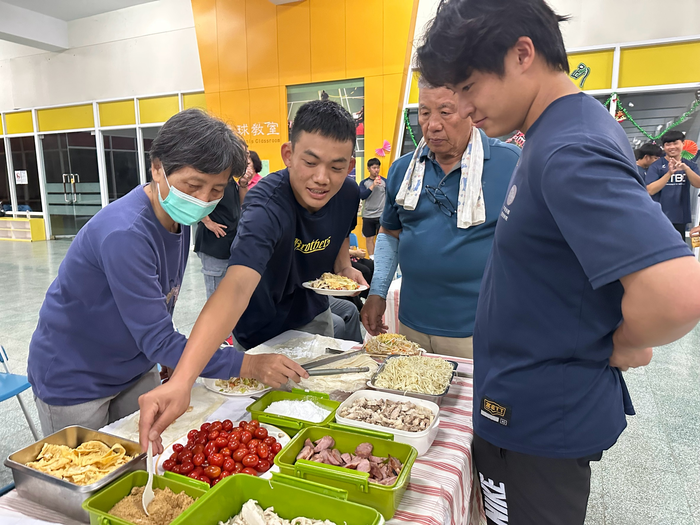 圖說：樂齡大學學員準備豐盛的菜餚和大學生一起包春捲(圖/中信科技大學提供)
