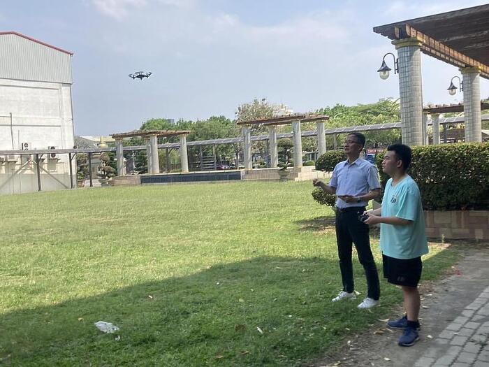 中信科大飛修系主任林松義老師（左）指導育德工家無人機社團學生操作無人機。