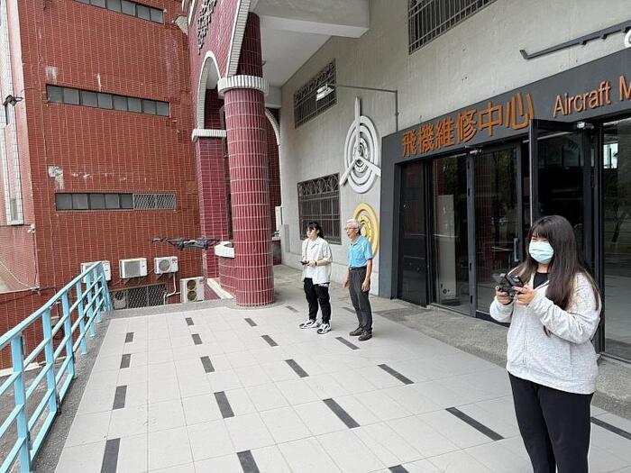 社團指導老師張偉國（中）指導社團學生林沛慈（左）、蔡沛臻（右）操作無人機。