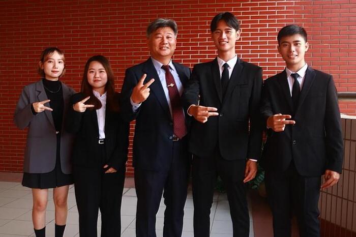 圖說：行銷三忠張良愷（右二）、陳有智（右一）與導師和學生會幹部在學校合照。